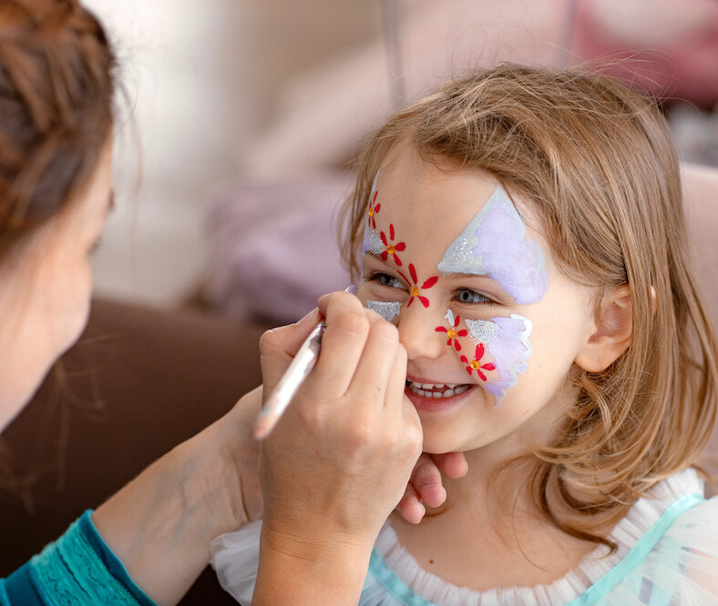 smiling happy child with face art aqua grimm on birthday or halloween party. face art painting